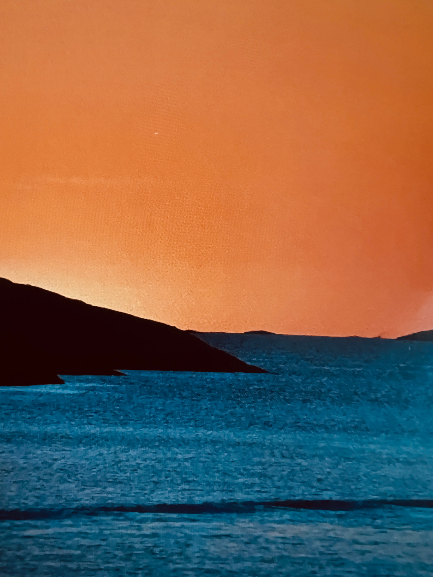 Orange himmel över blått hav
